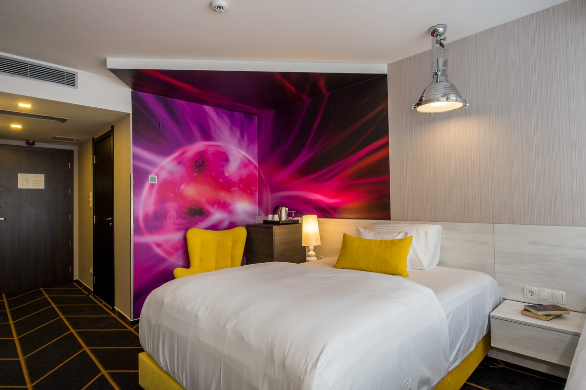 Double room with yellow cushions, a colourful light painting on the wall