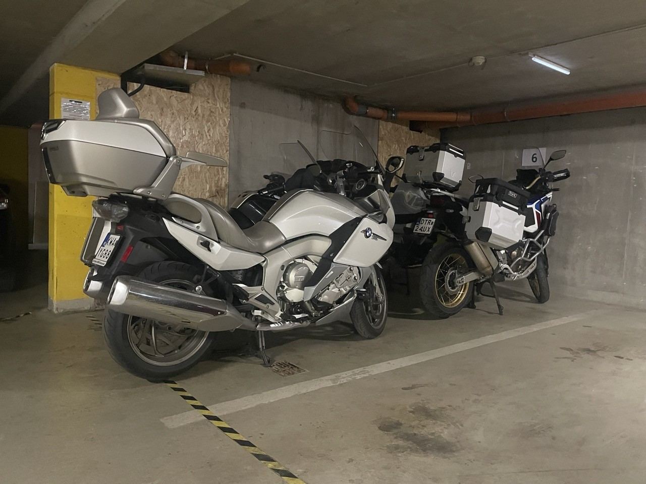Ugyanaz a két motor a szálloda mélygarázsában, a dobozok a motoron