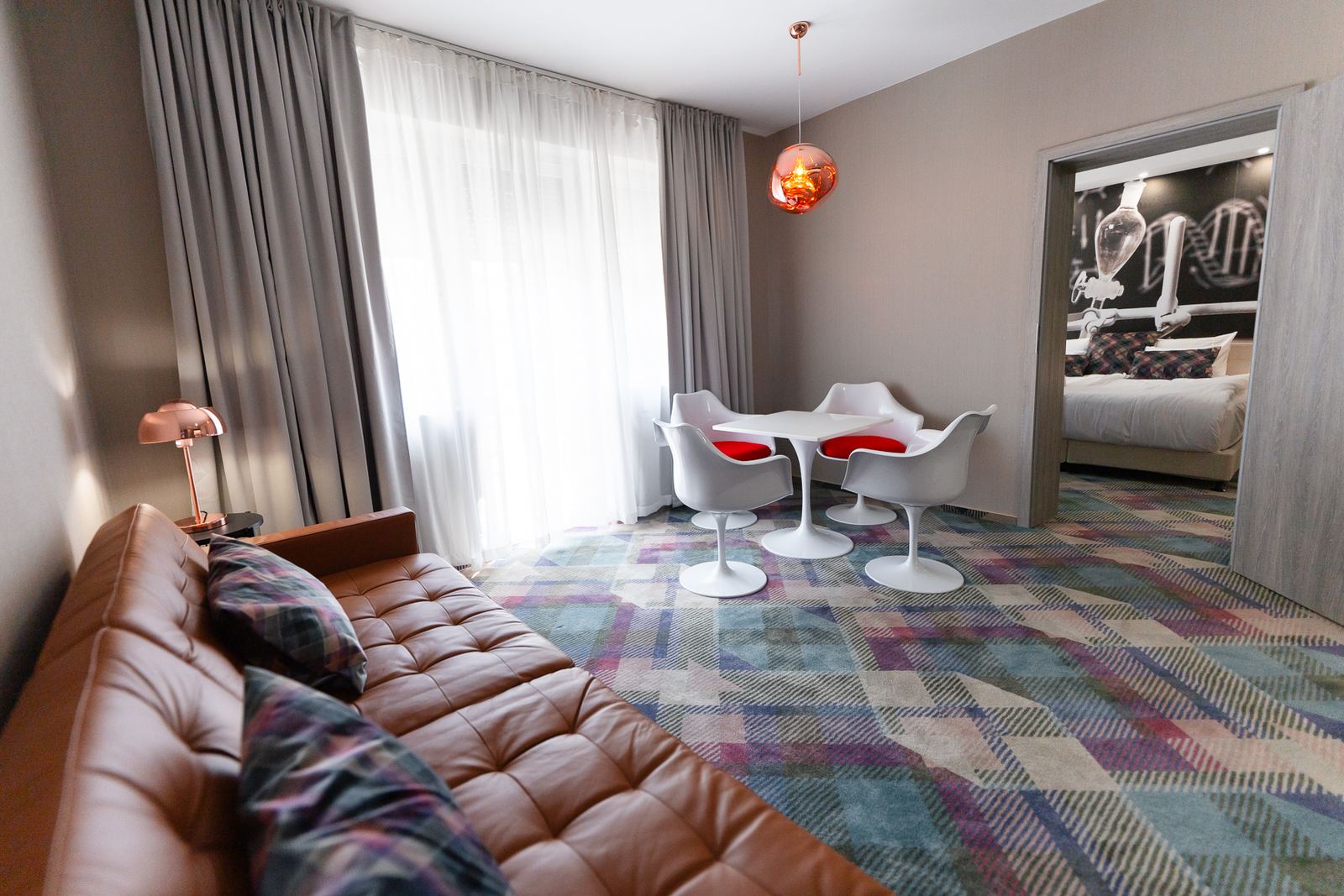 Dnevna soba apartmana sa kožnom sofom i trpezarijskim stolom